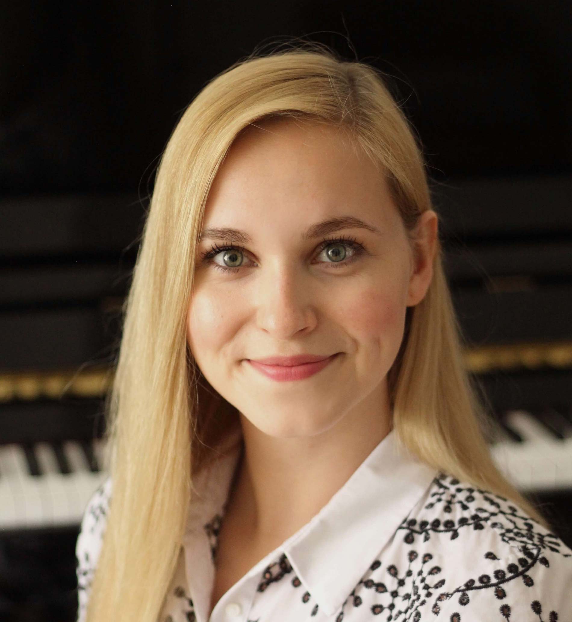 a woman with long blonde hair smiling at the camera